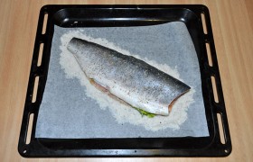 Подготавливаем заранее размороженную горбушу: освобождаем от всех плавников, головы и хвоста, промываем и обсушиваем с помощью бумажных полотенец. Кладем тушку на слой соли, солим немного внутри и сюда же – несколько веточек петрушки, а сверху посыпаем прованскими травами.