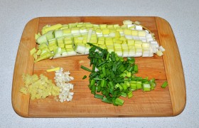 Тоже кубиком, но не больше 10 мм, нарезаем белую часть стебля лука-порея, рубим зеленый лук, мелко – корень имбиря и чеснок. И  несколько минут перекаливаем на сухой сковороде очищенный арахис.