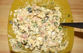 Для начинки рулетиков мелко рубим бекон, лук, огурцы, яйца, чеснок, кинзу и петрушку, добавляем для связи компонентов майонез, вымешиваем начинку.