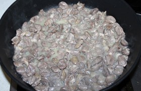 Перекаливаем на самом сильном огне в просторной сковороде растительное масло и при постоянном помешивании слегка обжариваем сердечки, только до того момента, когда они потеряют розовый цвет и выделят сок. Тогда накрываем крышкой и, переставив на дальнюю конфорку со средне-слабым огнем, оставляем потихоньку тушиться.