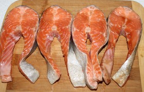 Рыбные стейки (купленные в супермаркете или нарезанные самостоятельно) смазываем соевым соусом. Натираем измельченным в прессе чесноком, с обеих сторон посыпаем солью и смесью перцев из мельнички.