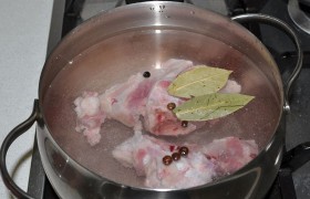 А кости рульки кладем в небольшое количество холодной воды, бросаем лавровые листья и перец, и варим бульон, который нам скоро понадобится. Солим.