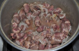 Засыпаем в казан сердечки, и вместе с луком, при периодическом перемешивании, они жарятся 15-18 минут. Огонь не снижаем.