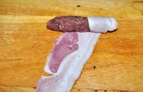 Из шариков формуем тонкие колбаски- чевапчичи , которые оборачиваем полоской бекона. 