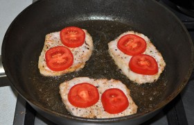 Переворачиваем, тут же кладем на мясо помидоры, 
