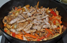 Возвращаем в сковороду свинину, вливаем, перемешав еще раз, соус, бросаем чеснок и зелень, все время помешивая, даем покипеть минуту – и выключаем. Подаем сразу.