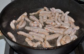 Ставим просторную толстодонную сковороду на самый сильный огонь, наливаем масло, ждем несколько минут, пока оно  перекалится . Выкладываем мясную соломку, посыпаем перцем, обжариваем, перемешивая, примерно 2 минуты, ровно до того момента, когда мясо станет светлым и еще только начинает браться корочкой. Выкладываем в тарелку.