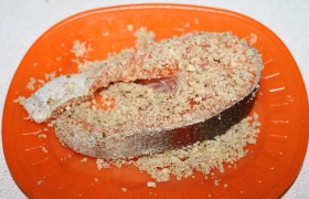 Обваливаем стейки в орехах, прижимая ладонями орехи к рыбе.