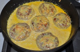 Закладываем биточки в соус. Переворачиваем или просто поливаем соусом с помощью ложки. Переключив огонь на малый, тушим под крышкой 6-8 минут.