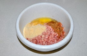 Фарш мы накрутили из свиного окорока и грудинки. Засыпаем в него панировочные сухари, вбиваем яйцо, посыпаем приправами. Руками 2-3 минуты вымешиваем и  отбиваем .