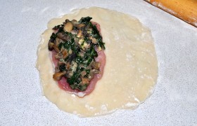 Делим тесто на соответствующее количество кусочков, раскатываем. Кладем на одну половину отбивную, слой начинки, накрываем второй половиной и защипываем край.