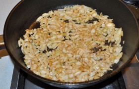 Всыпаем в сковороду лук, переводим огонь на средний, пассеруем лук 8-10 минут, помешивая часто.