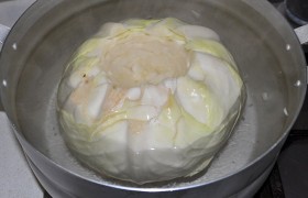 Поставив варить рис (не до полной готовности, на 12-15 минут кипения под крышкой), готовим капустные листья. С летней капустой проще, а вот с зимней хлопот больше, листья с нее легко не снимешь. Вырезаем кочерыжку, кладем кочан в кипящую воду, наливаем кипяток в отверстие кочана, через несколько минут капуста смягчится –