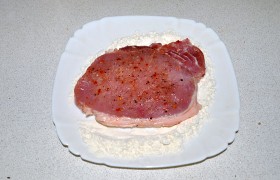 Панируем отбивные в муке, излишки – стряхиваем.