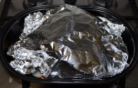 На 10 минут ставим в духовку при 220°. Это позволит свинине схватиться легкой корочкой и удержать внутренние соки. Температуру снижаем до 160°, окорок смазываем маринадом. Укрываем сверху листом фольги. 