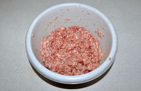 В свежий или размороженный фарш засыпаем овсяные хлопья (или сухари), приправы, вливаем часть молока, перемешиваем, оставляем на 10-12 минут для набухания овсянки или сухарей. Добавив еще молока, снова вымешиваем и 20-22 раза отбиваем фарш .