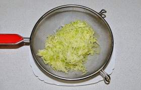 Очищенный от кожи и семян кабачок натираем на мелкой терке. Сильно отжимаем массу, но часть сока оставляем.