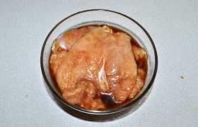 Мясо посыпаем перцем. Вливаем в миску соевый соус, обмакиваем в  него отбивные, складываем стопкой, заливаем остатками соуса. Маринуем не менее получаса.