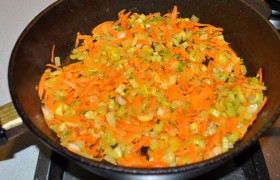 Когда все кусочки обжарены и сложены на тарелке, добавляем в сковороду еще немного масла, засыпаем нарезанные лук, сельдерей, морковь, пассеруем на среднем огне 5-7 минут, заливаем вино, и минут 5-6 овощи тушатся, пока вино выпаривается.