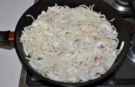 Сверху засыпаем луком. Закрываем. И 20 минут лук потихоньку  карамелизуетс я, а грудинка – тушится, точнее даже – пропаривается.