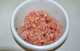 Мелко рубим луковицу, добавляем к фаршу, засыпаем приправу, соль, свежемолотую смесь перцев, для сочности – молока. Вымешиваем и немного – 12-15 раз – отбиваем .