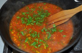 Выложив фрикадельки, споласкиваем сковороду (или берем другую), разогреваем – теперь на среднем огне. Даем расплавиться сливочному маслу, кладем томатную пасту, хорошенько перемешиваем, через 1-1,5 минуты кипения солим, добавляем порубленные дольки чеснока, петрушку, горячий бульон (воду).