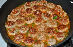 Еще через минуту-две  – закладываем все фрикадельки. Закипело - уводим огонь на небольшой, а сковороду накрываем крышкой, под которой фрикадельки тушатся 6-7 минут.