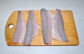С тушек срезаем плавники, очищаем от чешуи, затем отделяем головы и хвосты, потрошим. Промываем и подсушиваем бумажными полотенцами. Аккуратно отделяем филе вместе с кожей.