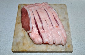 Кусок корейки, промытый и с качественно просушенной бумажными полотенцами поверхностью, делим (поперек волокон мяса) на ломти до 18-20-мм толщины. 