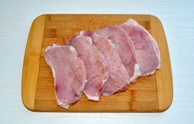 Порядок подготовки мяса у нас привычный для отбивных: мясо мы промываем, сложенными бумажными полотенцами тщательно снимаем влагу, нарезаем на 5-6 пластов (не забудем – поперек волокон). И, закладывая в пакетик из пищевой пленки, отбивае м обе стороны, надрезав слой сала, если он стягивает отбивную.