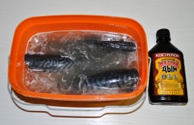 Кладем в подходящую посуду, заливаем холодной чистой водой, солим, вливаем жидкий дым, кладем перец, лавровый лист. Перемешиваем, кладем блюдце или тарелку, чтобы не всплыла рыба, закрываем плотной крышкой или затягиваем пленкой. Оставляем в холодном месте минимум на 12 часов, лучше – на сутки.