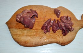 Куриные печенки промываем, поместив в дуршлаг. Когда воды не осталось – нарезаем дольками, попутно удаляя жир.